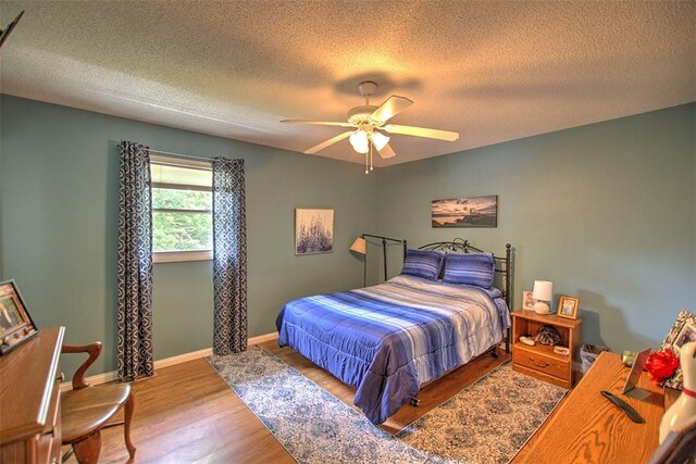 1065 S Wildwood Dr, Mt Zion, IL 62549 - bedroom featuring a textured ceiling, wood finished floors, and ceiling fan