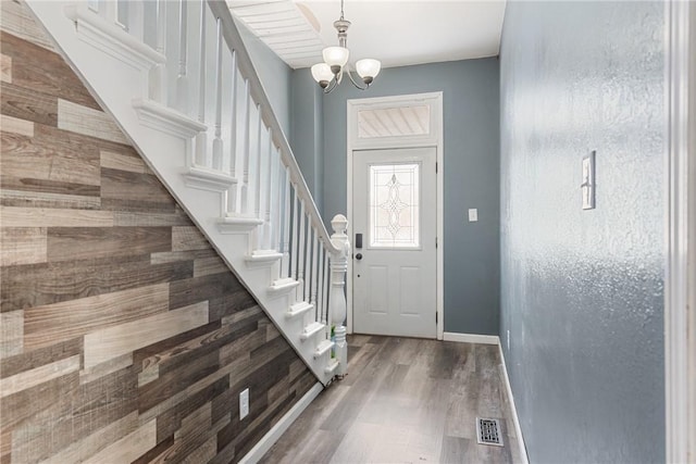 entryway featuring wood-type flooring and a chandelier