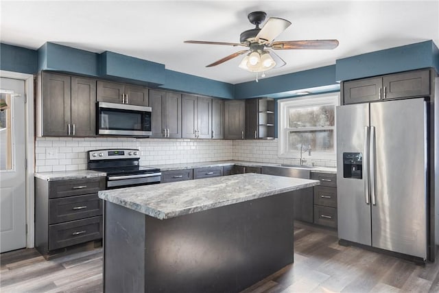 kitchen featuring stainless steel appliances, dark hardwood / wood-style floors, sink, and a kitchen island