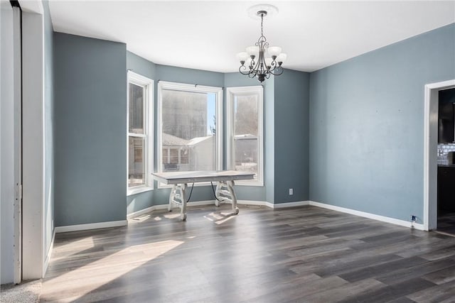 unfurnished dining area with an inviting chandelier and dark hardwood / wood-style floors