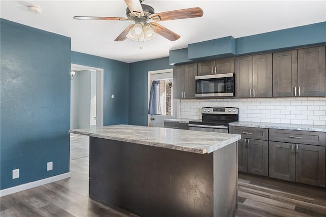 kitchen featuring dark brown cabinets, stainless steel appliances, dark hardwood / wood-style floors, tasteful backsplash, and light stone countertops