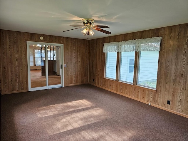 202 E Madison St, Toledo, IL 62468 - empty room with carpet floors, a ceiling fan, wood walls, and baseboards