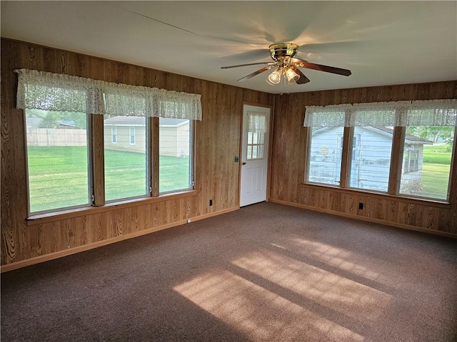202 E Madison St, Toledo, IL 62468 - empty room with carpet floors, ceiling fan, wood walls, and baseboards