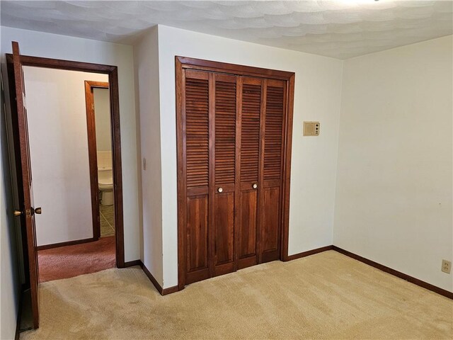 202 E Madison St, Toledo, IL 62468 - unfurnished bedroom with light colored carpet, baseboards, and a closet