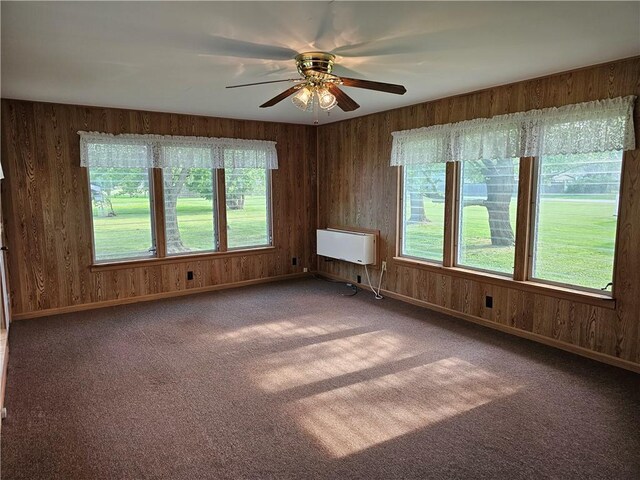 202 E Madison St, Toledo, IL 62468 - carpeted empty room with wood walls, a ceiling fan, baseboards, and heating unit
