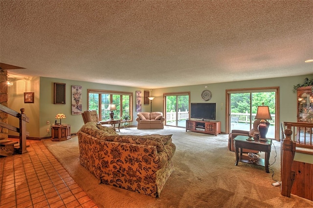 living room with carpet, a textured ceiling, and a wealth of natural light