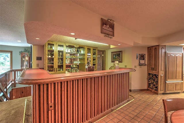 bar featuring light tile patterned floors and a textured ceiling