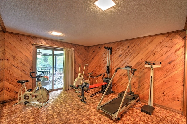 workout room featuring wooden walls and a textured ceiling