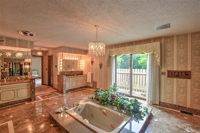 bathroom with a bath, a textured ceiling, vanity, and a chandelier