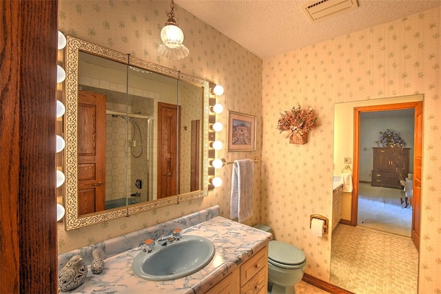 bathroom with vanity, a textured ceiling, toilet, and walk in shower