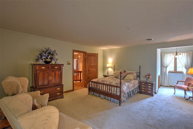 carpeted bedroom featuring a textured ceiling and a notable chandelier