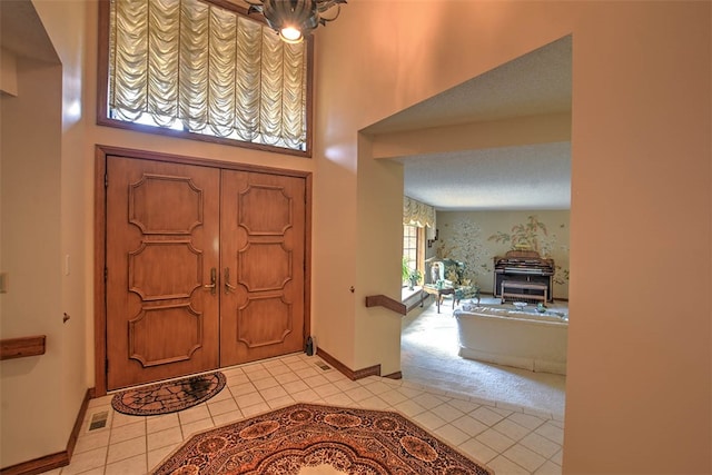 foyer featuring light tile patterned floors and a textured ceiling