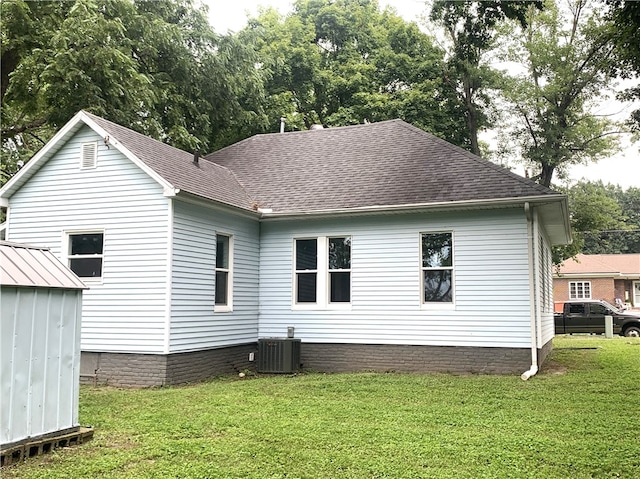 rear view of house featuring a yard, a shed, and cooling unit