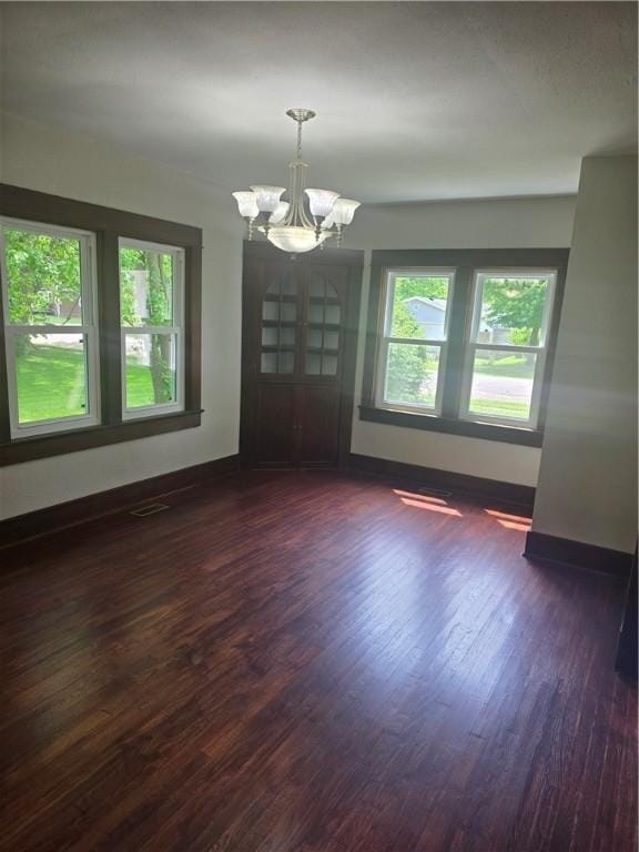 107 S Edwards St, Altamont, IL 62411 - empty room featuring a chandelier, healthy amount of natural light, and dark wood finished floors