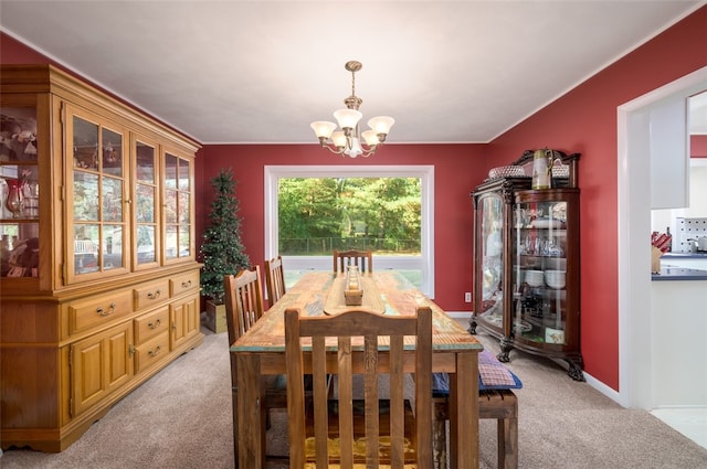 dining area featuring a notable chandelier and light colored carpet