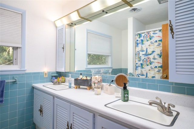 bathroom featuring vanity and tile walls