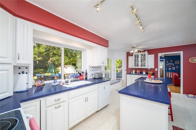 kitchen with light wood-type flooring, rail lighting, a kitchen island, dishwasher, and white cabinetry