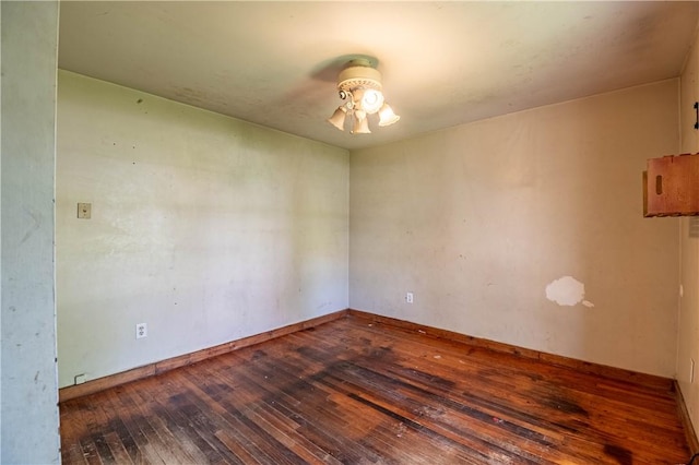 spare room featuring baseboards, a ceiling fan, and hardwood / wood-style flooring