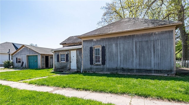 view of front facade featuring roof with shingles and a front yard
