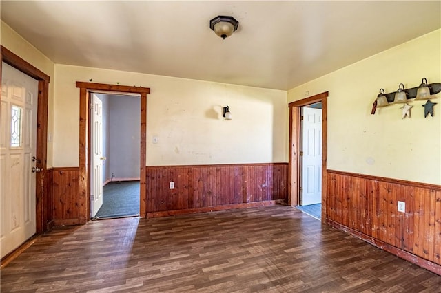 interior space featuring wainscoting, wood walls, and wood finished floors