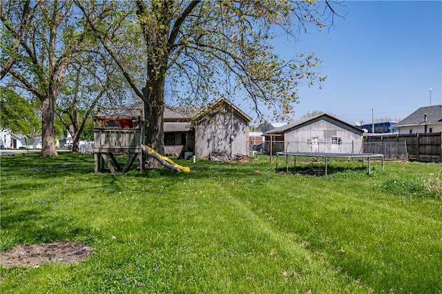 view of yard with fence and a trampoline
