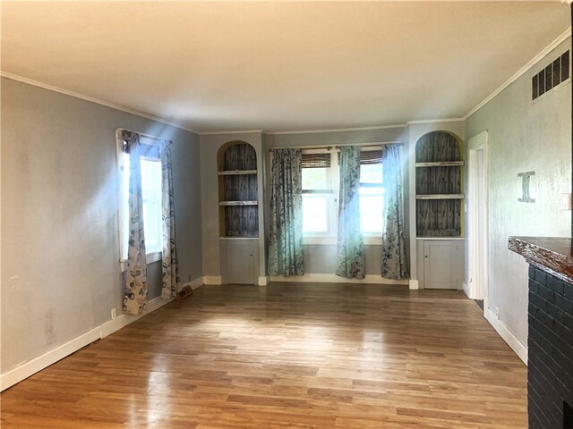 647 E 2100 N Rd, Assumption, IL 62510 - unfurnished living room featuring crown molding, built in features, wood finished floors, and healthy amount of natural light