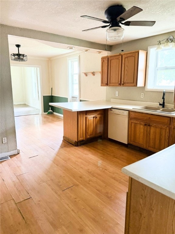 709 10th St, Charleston, IL 61920 - kitchen with white dishwasher, a sink, a peninsula, light countertops, and brown cabinets