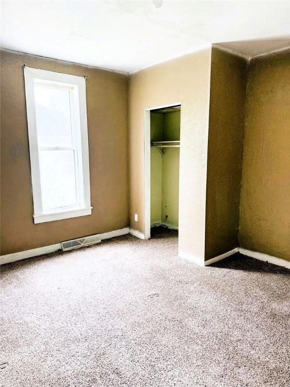 709 10th St, Charleston, IL 61920 - unfurnished bedroom featuring carpet flooring, a closet, and baseboards