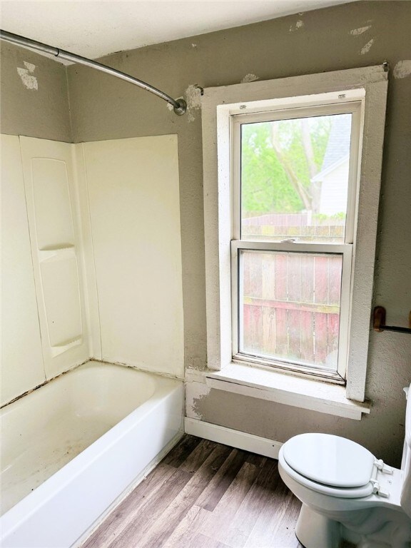 709 10th St, Charleston, IL 61920 - bathroom with wood finished floors, toilet, and bathing tub / shower combination