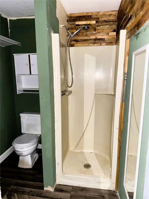 709 10th St, Charleston, IL 61920 - bathroom featuring a shower stall, toilet, and wood finished floors