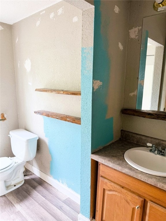 709 10th St, Charleston, IL 61920 - bathroom featuring wood finished floors, vanity, toilet, and baseboards