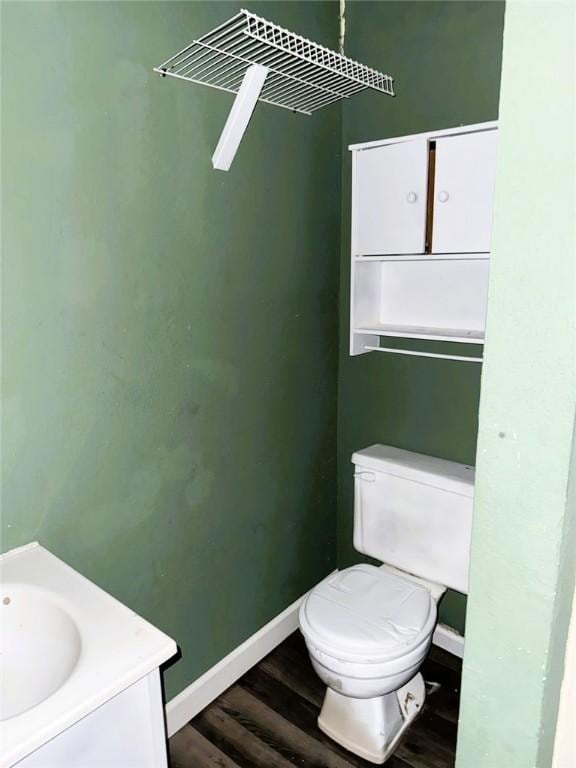 709 10th St, Charleston, IL 61920 - bathroom with wood finished floors, toilet, baseboards, and vanity