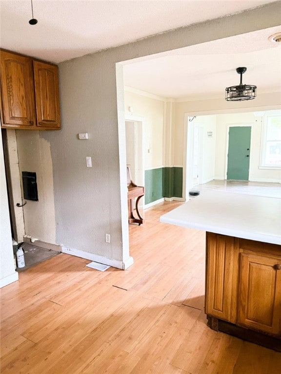 709 10th St, Charleston, IL 61920 - kitchen featuring brown cabinets, light wood-style floors, baseboards, and light countertops