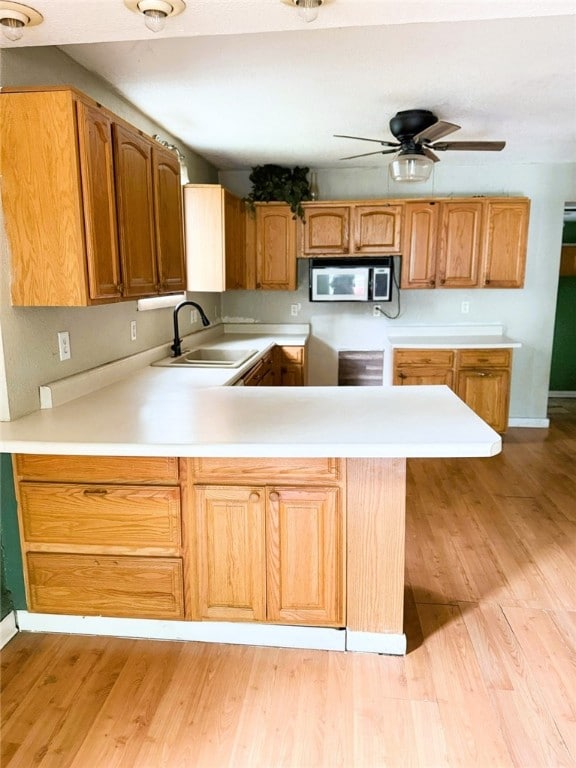 709 10th St, Charleston, IL 61920 - kitchen with a sink, stainless steel microwave, a peninsula, ceiling fan, and light countertops