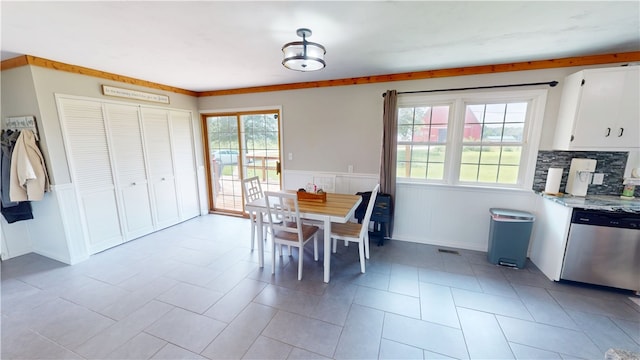 2251 W Stone Bluff Rd, Covington, IN 47932 - dining space with healthy amount of natural light, a wainscoted wall, and light tile patterned floors
