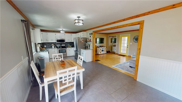 2251 W Stone Bluff Rd, Covington, IN 47932 - dining area with a wainscoted wall, a baseboard heating unit, light tile patterned floors, and ornamental molding