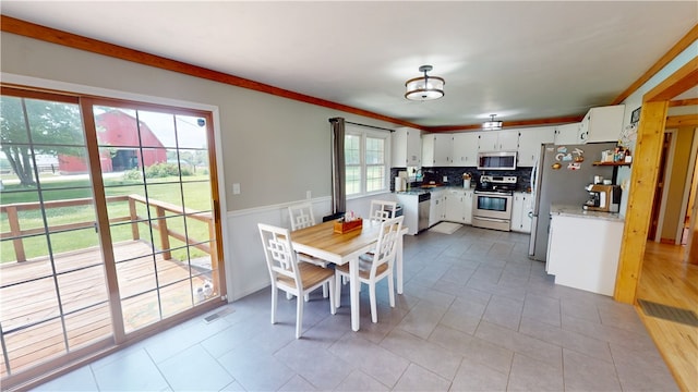 2251 W Stone Bluff Rd, Covington, IN 47932 - kitchen with stainless steel appliances, white cabinetry, backsplash, a wainscoted wall, and light countertops