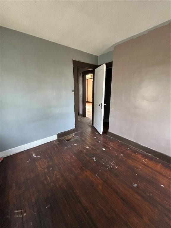 unfurnished bedroom with dark hardwood / wood-style flooring