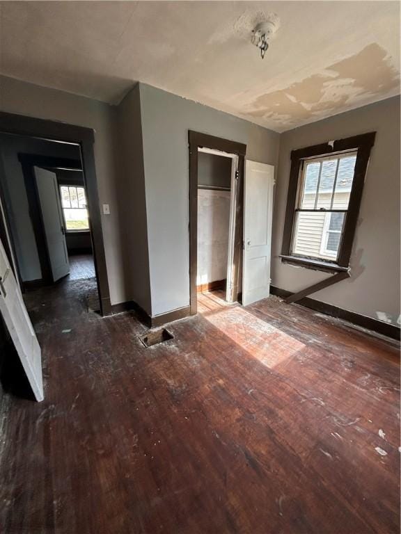 unfurnished bedroom featuring dark hardwood / wood-style flooring and multiple windows