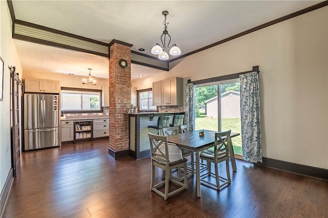 503 W Harrison St, Sullivan, IL 61951 - dining area with a chandelier, ornamental molding, dark wood-style flooring, and decorative columns