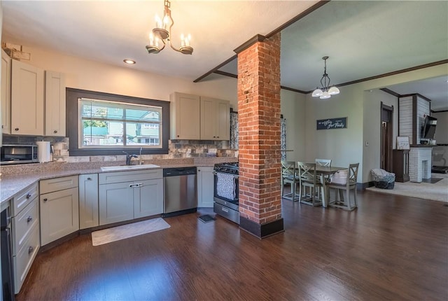 503 W Harrison St, Sullivan, IL 61951 - kitchen with stainless steel appliances, dark wood-type flooring, decorative backsplash, ornate columns, and decorative light fixtures