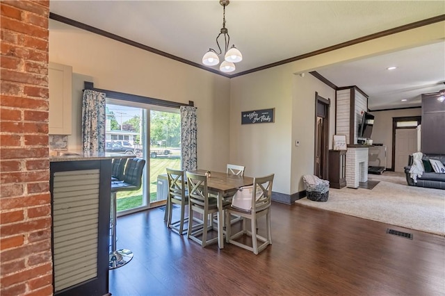 503 W Harrison St, Sullivan, IL 61951 - dining space with crown molding, dark wood-style flooring, recessed lighting, and a chandelier