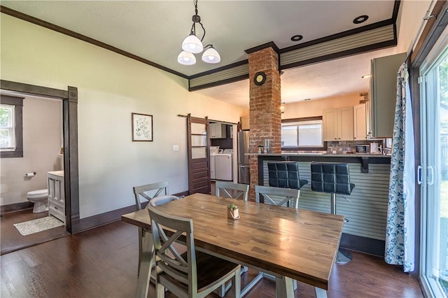 503 W Harrison St, Sullivan, IL 61951 - dining area featuring crown molding, dark wood finished floors, healthy amount of natural light, and decorative columns
