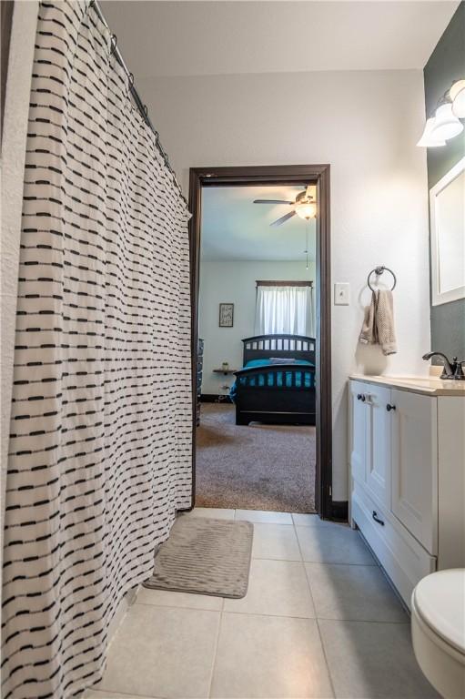 503 W Harrison St, Sullivan, IL 61951 - full bathroom featuring vanity, a shower with shower curtain, tile patterned flooring, and a ceiling fan