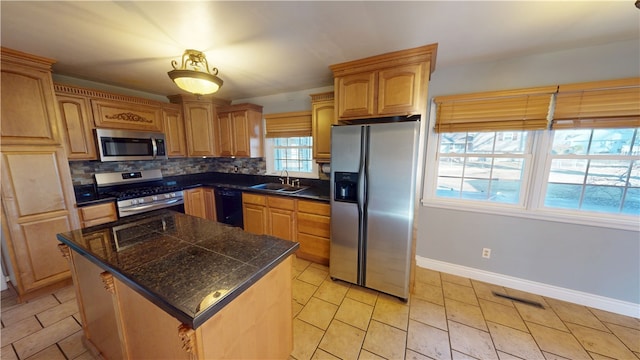 kitchen with stainless steel appliances, a sink, baseboards, tile counters, and decorative backsplash