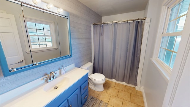 bathroom featuring toilet, wooden walls, vanity, a shower with curtain, and tile patterned floors