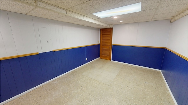 empty room featuring a drop ceiling and tile patterned floors