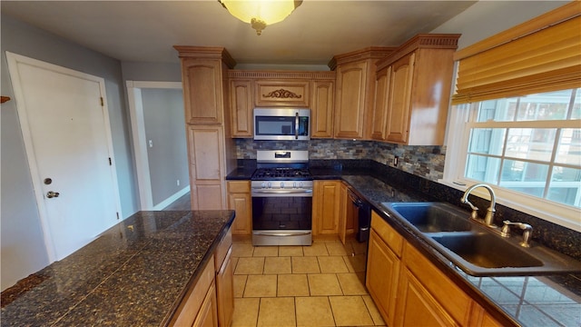 kitchen with light tile patterned floors, tasteful backsplash, tile countertops, stainless steel appliances, and a sink