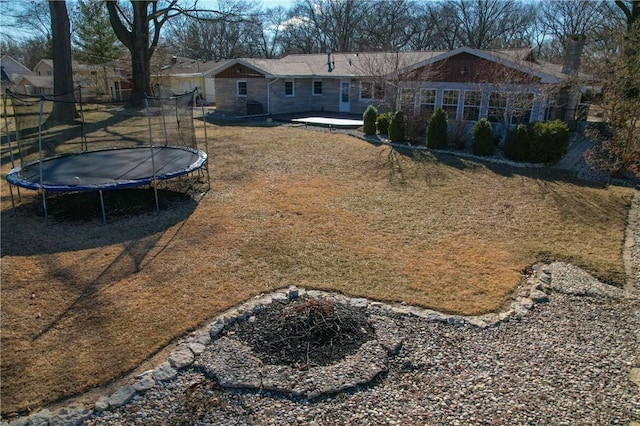 view of yard with a trampoline and a patio area