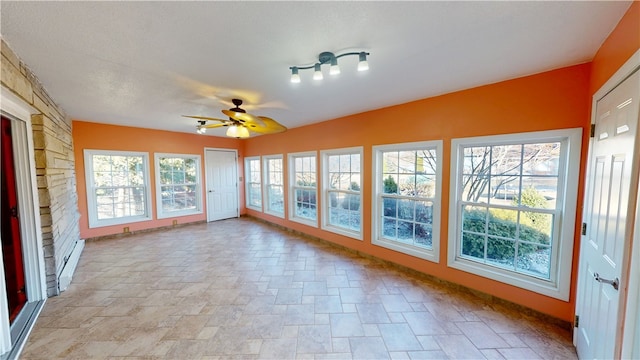 unfurnished sunroom with a baseboard radiator and ceiling fan